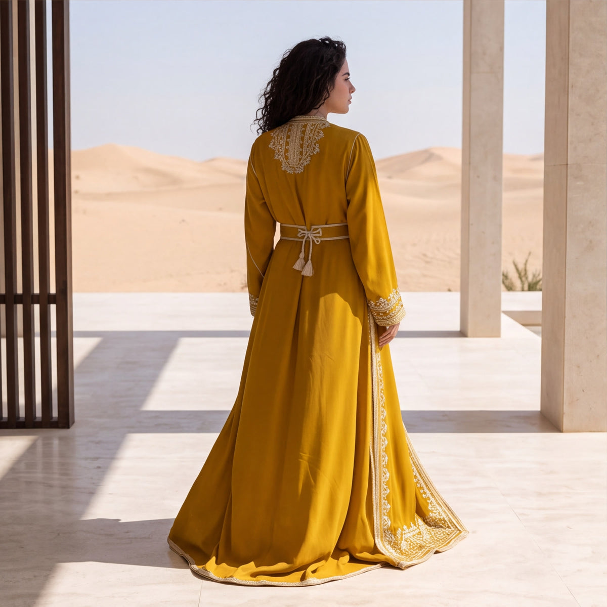 Back view of a woman wearing a floor-length mustard yellow kaftan.