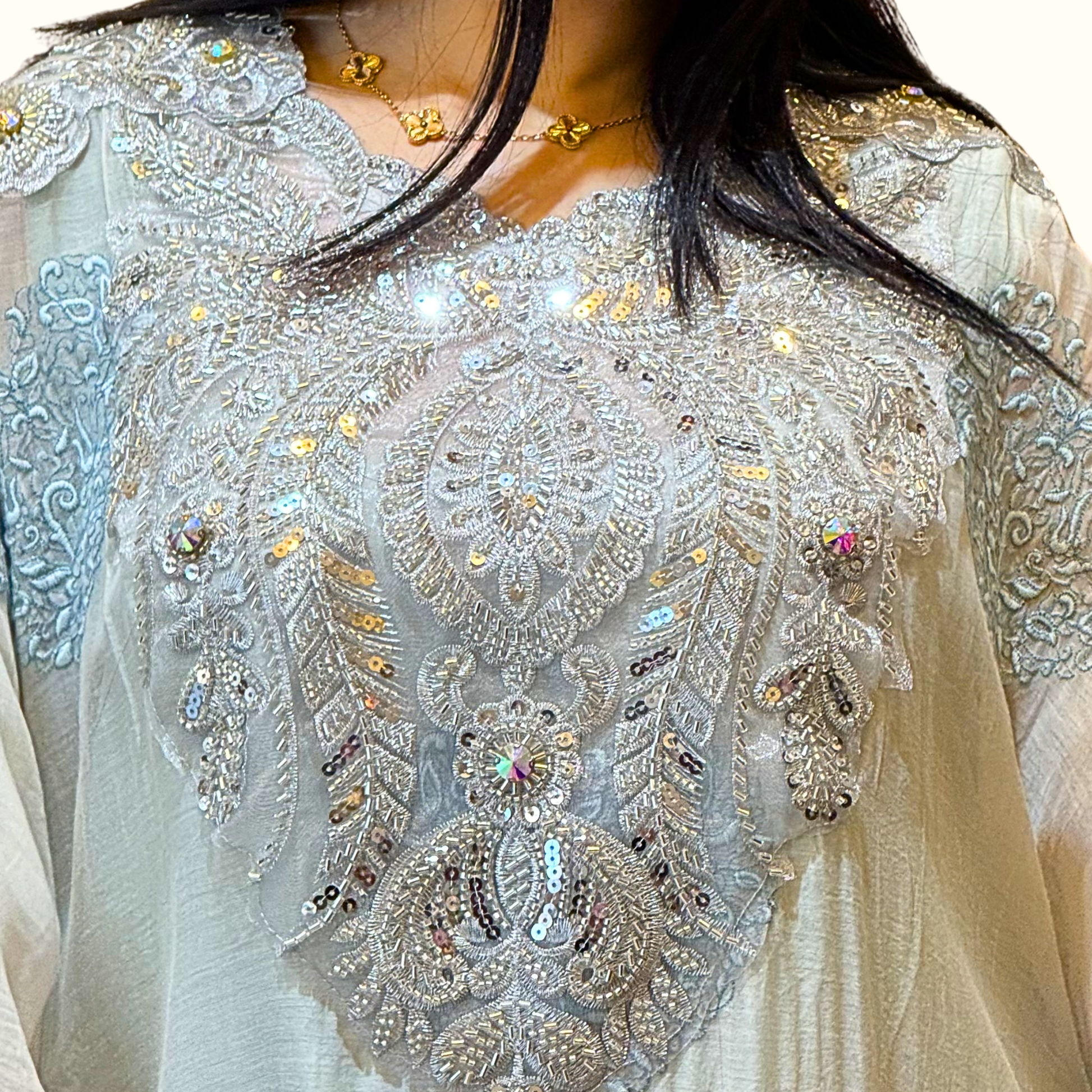 Close-up of the exquisite, heavy silver embroidery tracing the neckline of Rubeena Ameen powder blue dress