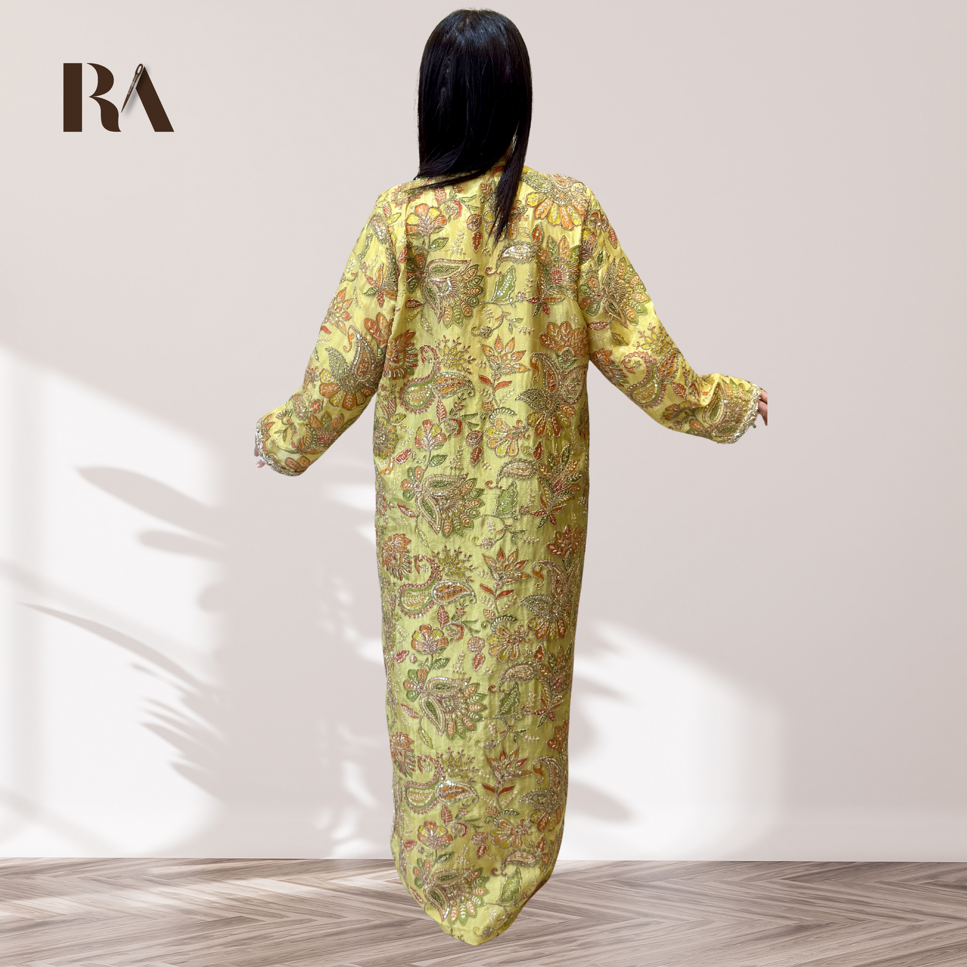 Close-up of detailed multi-color floral embroidery on Rubeena Ameen pistachio green silk dress