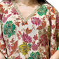 Close-up of green and pink floral embroidery on Rubeena Ameen natural crepe dress