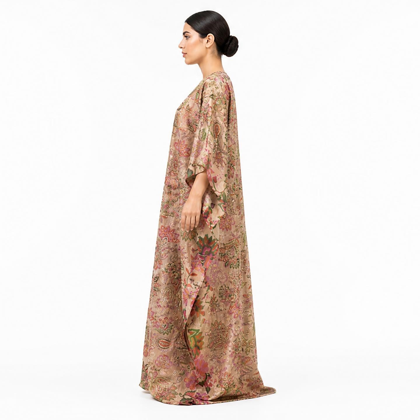 Woman wearing golden embroidered tissue silk kaftan maxi dress, side profile view