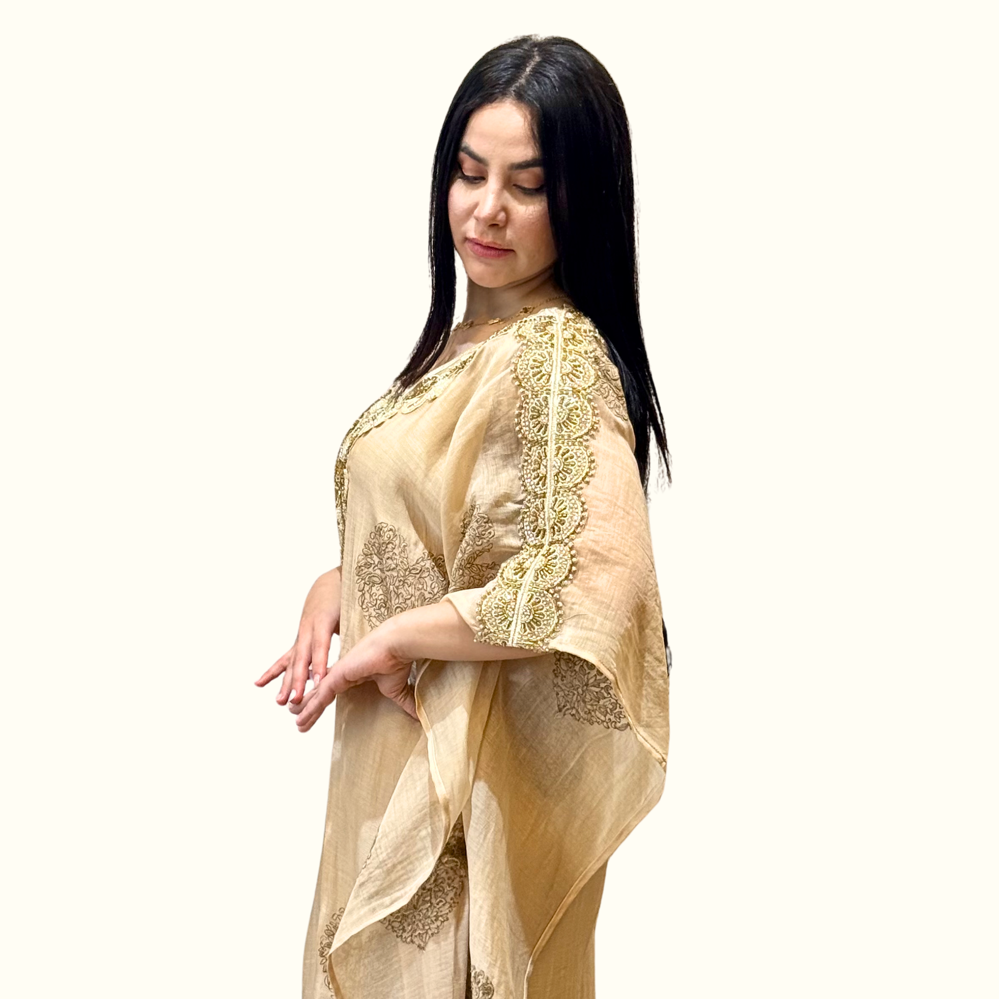 Side profile showing the fluid drape and wide kaftan sleeves of Rubeena Ameen gold embroidered cotton dress