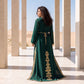 Back view of a woman wearing a floor-length emerald green kaftan with gold embroidered detailing, walking in a courtyard setting.