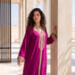 Close-up of the neckline and embroidery on a vibrant magenta handmade Moroccan kaftan.