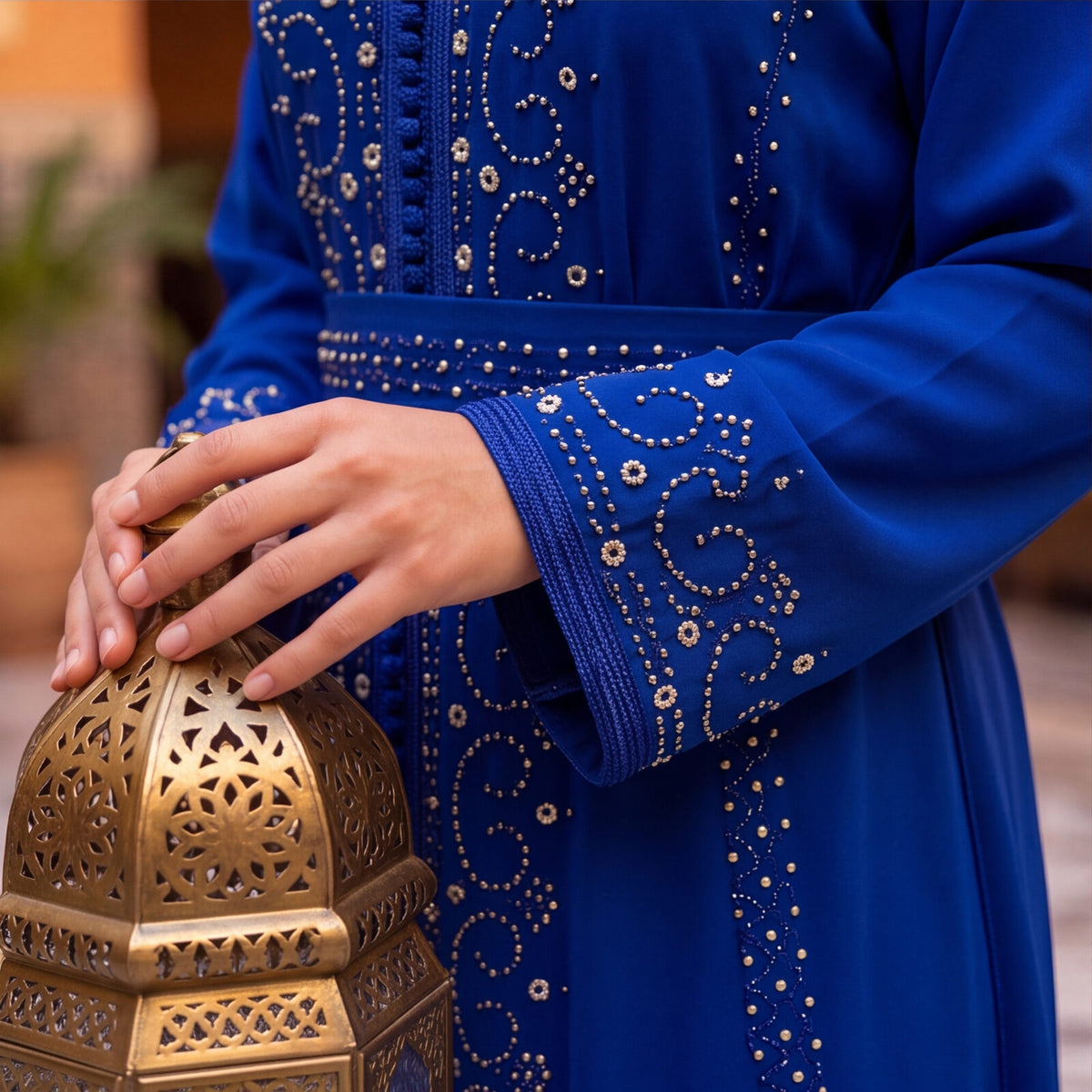 Close-up detail of the hand-embroidered silver crystal pattern and belt on the Marrakech Sapphire kaftan sleeve