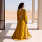 Back view of a woman wearing a floor-length mustard yellow kaftan.
