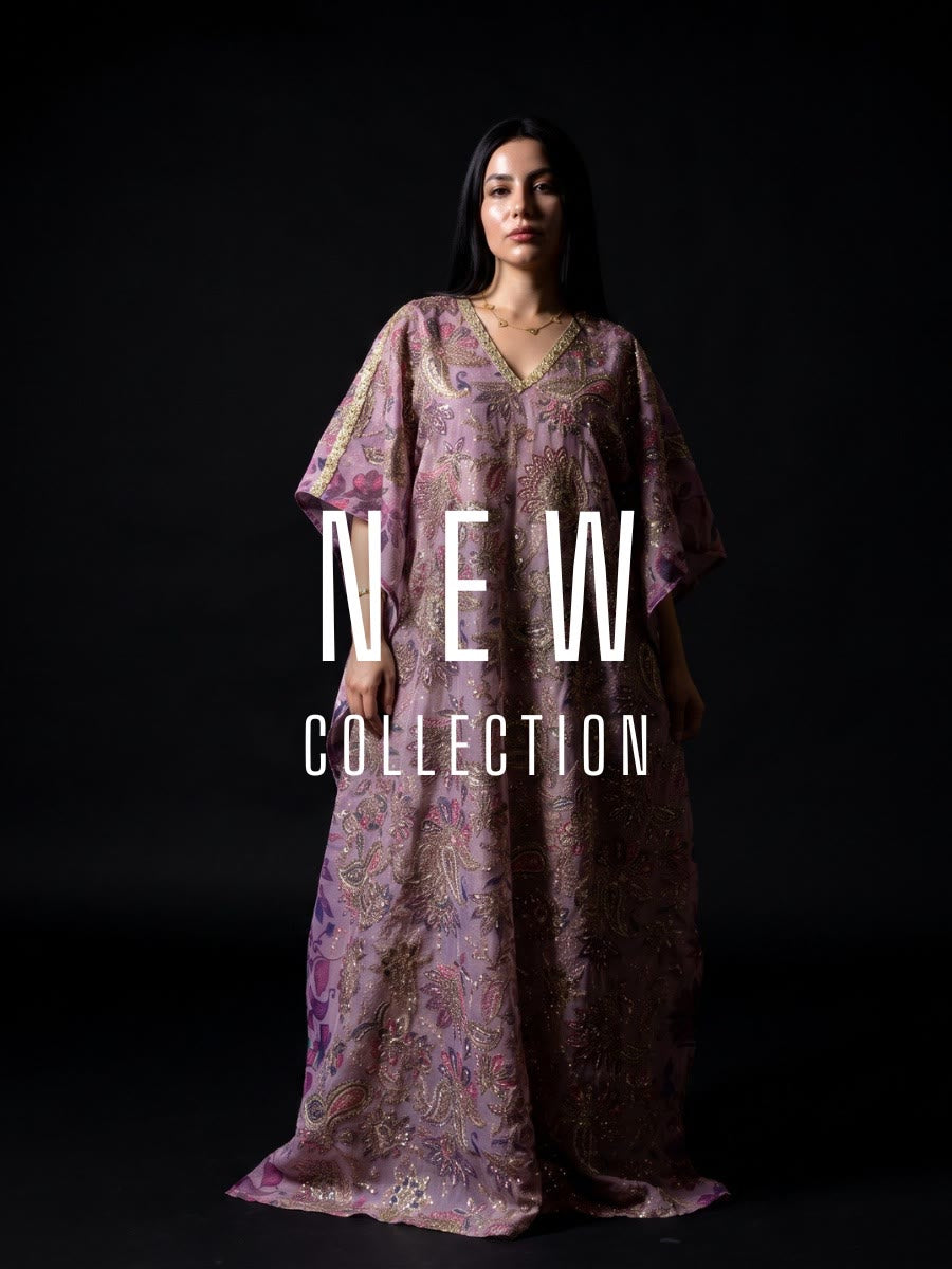 A woman modeling a long, loose kaftan dress with a purple and gold paisley pattern against a black studio background, with 'NEW COLLECTION' text overlaid across the center.