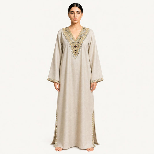 Woman wearing a beige pure linen kaftan with gold mirror-embroidered V-neckline, front view