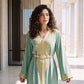 Close-up of the neckline and embroidered detailing on a sage green handmade Moroccan kaftan.